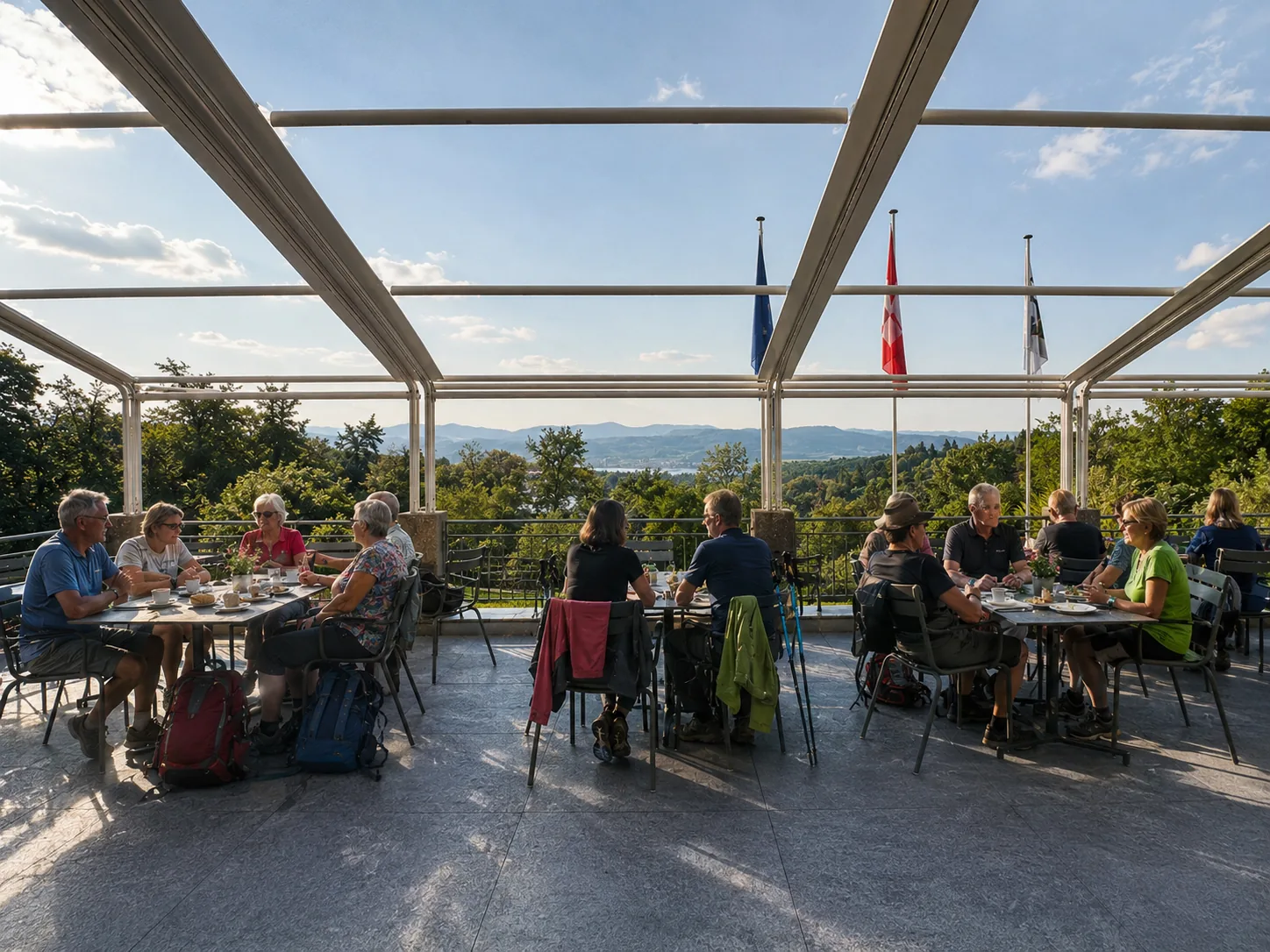 Gäste an Tischen auf der überdachten Panorama-Terrasse des Restaurant Waldrain mit weitem Blick über die Region